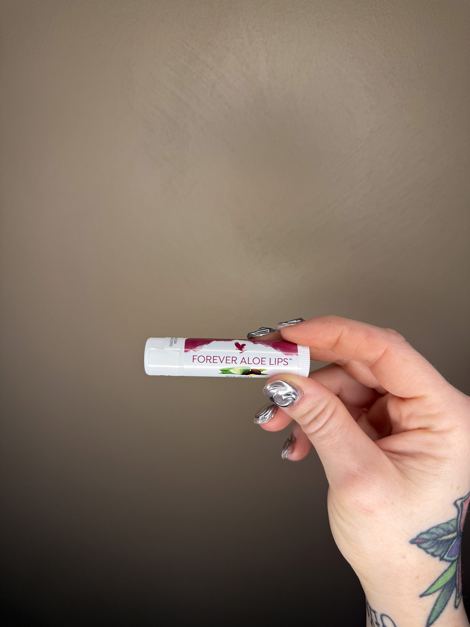Baume Forever Aloe Lips présenté par lestudiomarilou à Castelnaudary, main manucurée argent et tatouage floral